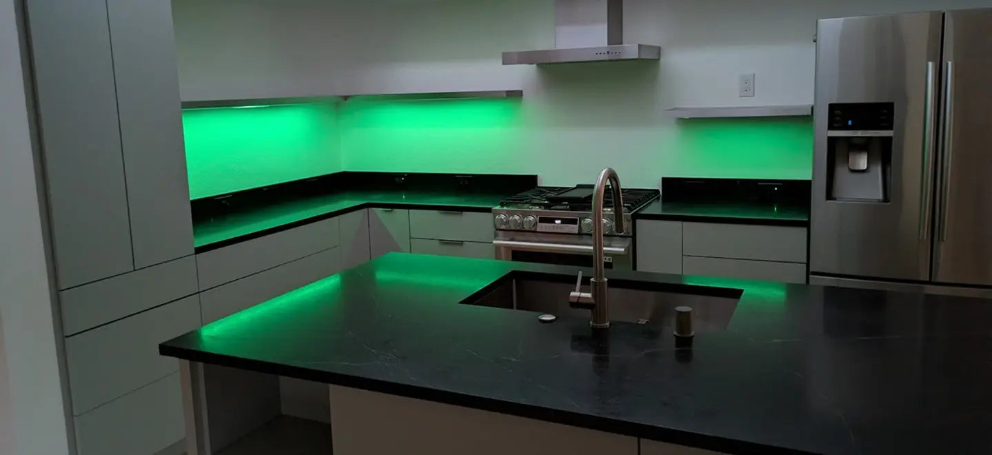 Modern kitchen with green LED lighting on the backsplash and island.