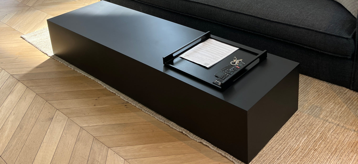 Black coffee table with a tray on a wooden floor
